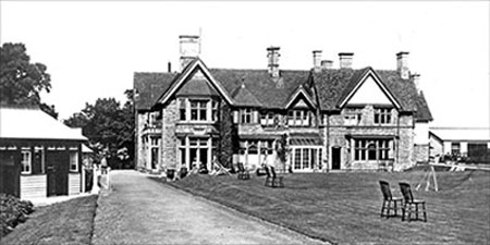 Photograph of the lawn at the San showing a tennis net just visible on the right hand side 